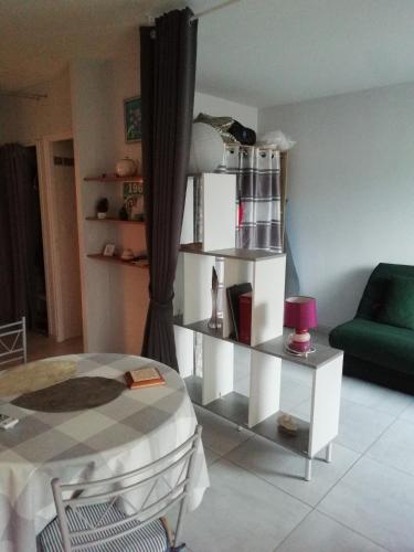 - un salon avec une table et un canapé vert dans l'établissement Studio ronce les bains, à La Tremblade