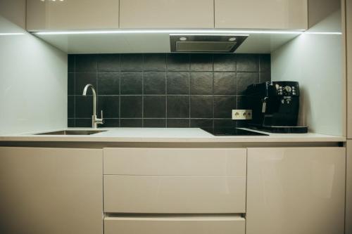a kitchen with white cabinets and a sink at ATLANT luxury apartments ТЦ ДЕПОТ in Chernivtsi