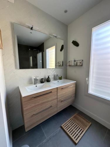 une salle de bain avec un lavabo et un grand miroir dans l'établissement Villa 8p vue mer piscine chauffée, à Mèze
