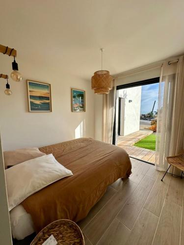 une chambre avec un grand lit et une grande fenêtre dans l'établissement Villa 8p vue mer piscine chauffée, à Mèze