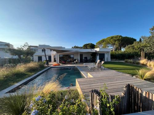 une cour arrière avec une piscine et une maison dans l'établissement Villa 8p vue mer piscine chauffée, à Mèze