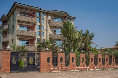a brick building with palm trees in front of it at A Charming Retreat and Free Breakfast in Lubumbashi