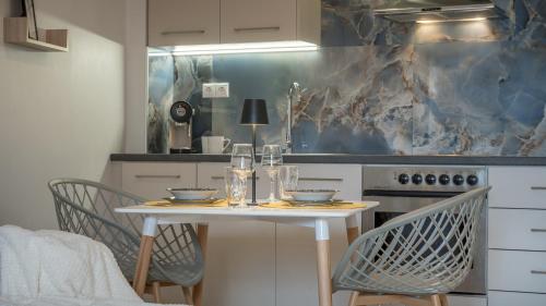 a kitchen with a table with two chairs and a stove at Leas little House in Preveza