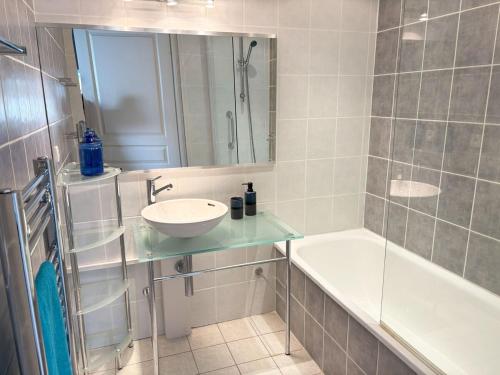 une salle de bain avec un lavabo et une baignoire dans l'établissement T3 vue mer, 2 chambres, piscine, terrasse, parking public gratuit à 150m, à Cannes
