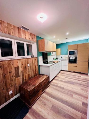 une cuisine avec un banc en bois au milieu dans l'établissement La Marmotte, au Bourg-dʼOisans