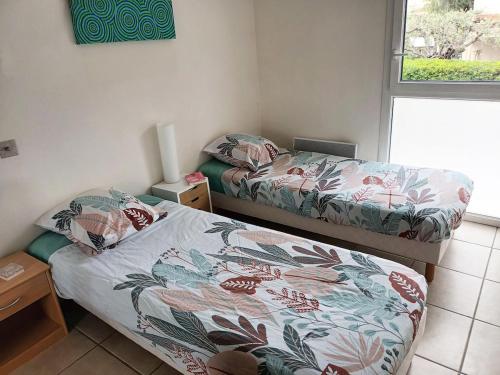 une petite chambre avec deux lits et une fenêtre dans l'établissement T3 vue mer, 2 chambres, piscine, terrasse, parking public gratuit à 150m, à Cannes