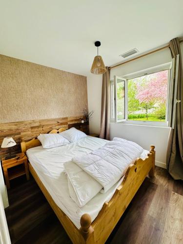 une chambre avec un grand lit et une fenêtre dans l'établissement La Marmotte, au Bourg-dʼOisans