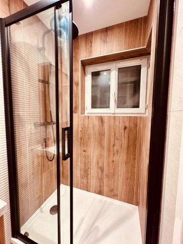 une douche avec une porte vitrée dans une salle de bain dans l'établissement La Marmotte, au Bourg-dʼOisans