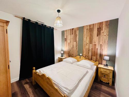a bedroom with a large bed and two night stands at La Marmotte in Le Bourg-dʼOisans