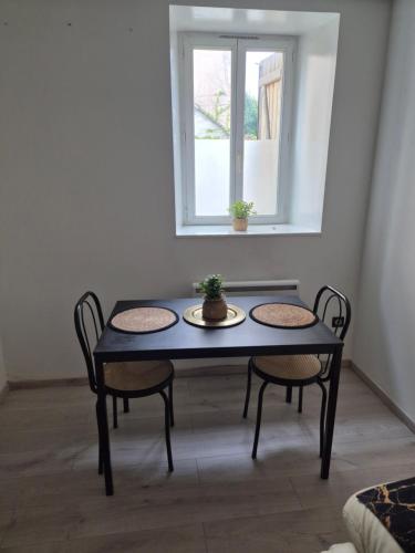 a blue table with two chairs and a window at L'Atelier-Appartement T2 tout confort in Saint-Gaudens