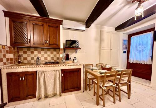 a kitchen with wooden cabinets and a table with chairs at Elegance home in Martina Franca