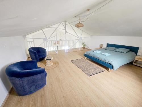 - une chambre avec un lit et deux chaises bleues dans l'établissement La Parenthèse Normande, Location maison avec jardin, à Merville-Franceville-Plage