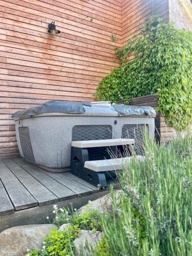 a bathtub sitting on a deck next to a wall at Chalupa Vale in Mohelno