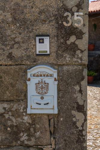 a sign on the side of a stone wall at House Sopo in Vila Nova de Cerveira