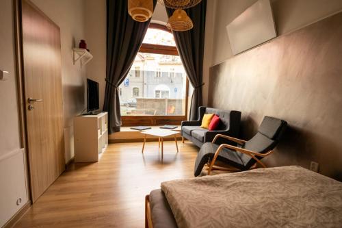a room with a bed and chairs and a window at U Koníka in Loket