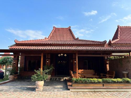 una casa con techo rojo y patio en 3 BR Java House ONLY 5 mins to Prambanan Temple, en Bugisan