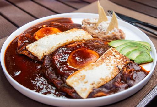 a plate of food with eggs and bread on a table at Hotel Boutique Casa Madero in Morelia