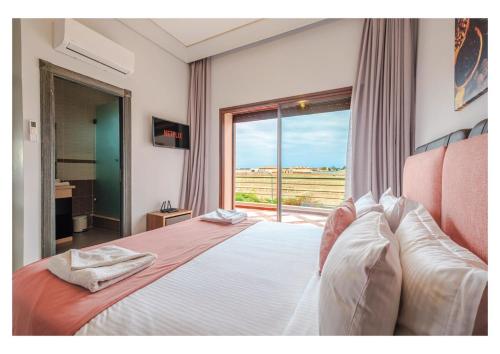 a bedroom with a large bed with a large window at Villa Dahlia Jacuzzi, Stove, Pool in Marrakesh