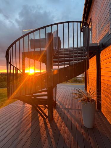 a bench on a deck with the sunset in the background at Ardtorna in Benderloch
