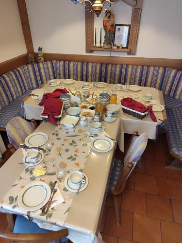 a table with plates and dishes on it at Privatzimmer Pendl in Abtenau