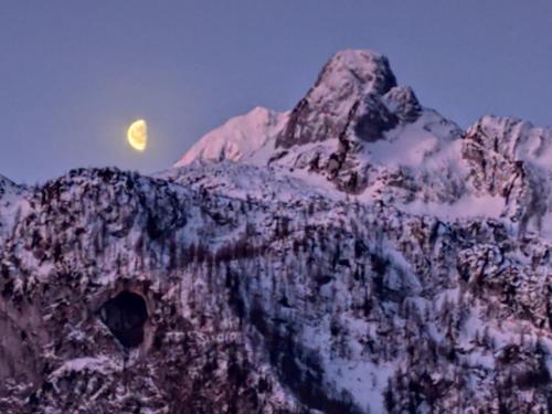 a mountain with the moon in the sky at Privatzimmer Pendl in Abtenau