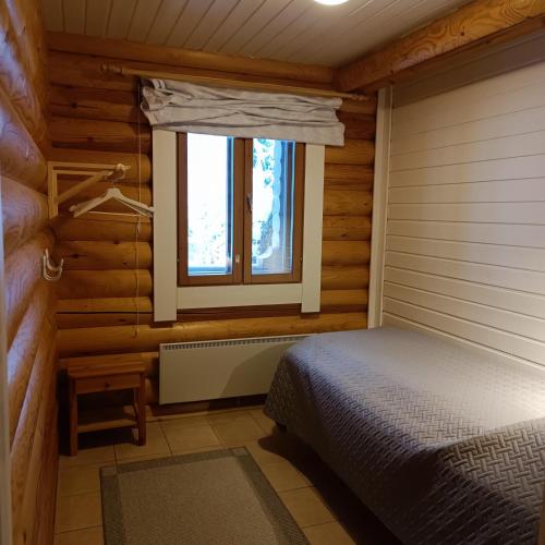 a bedroom with a bed and a window at Kolilla oy, Purnutar A in Kolinkylä