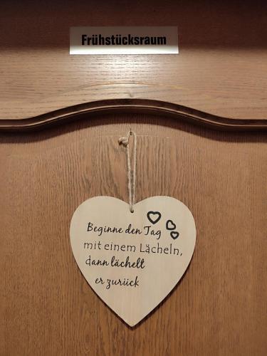 a white heart hanging on a wooden door at Privatzimmer Pendl in Abtenau
