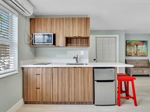 a kitchen with a sink and a red stool at Beachside 1BR Apt – Steps to Hollywood Dania in Dania Beach