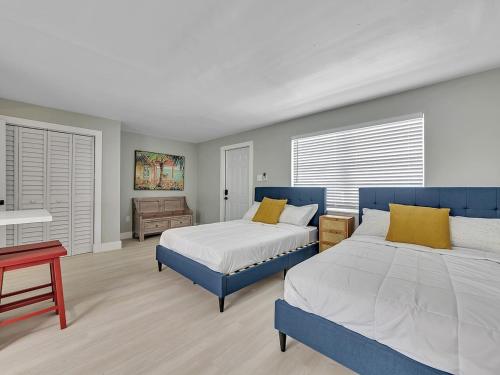 a bedroom with two beds and a table and a bed sidx sidx sidx at Beachside 1BR Apt – Steps to Hollywood Dania in Dania Beach