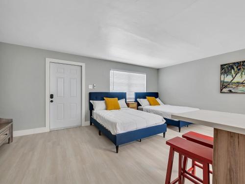 a bedroom with two beds and a desk in it at Beachside 1BR Apt – Steps to Hollywood Dania in Dania Beach