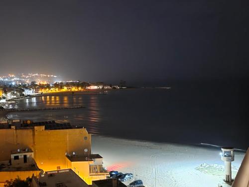 a view of the ocean at night with a city at Seven Sky appartment in Tunis in La Goulette
