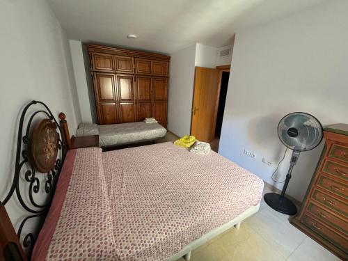 a small bedroom with two beds and a fan at apartamento vacacional roquetas de mar in Roquetas de Mar