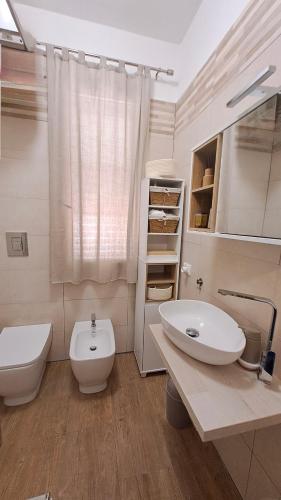 a white bathroom with a sink and a toilet at inKanto Room in Cefalù