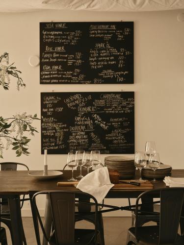 a dining room with a table with glasses and a chalkboard at Hotell Persnäs in Persnäs
