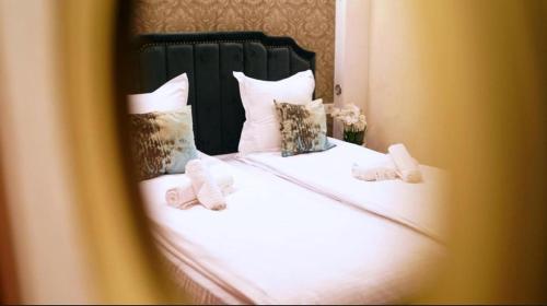 a bed with white sheets and pillows on it at pensiunea medellin in Tulcea
