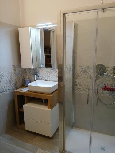 a bathroom with a glass shower and a sink at Il Mezzanino in Cervia