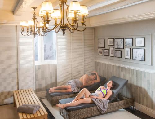 un homme et une femme dormant sur des chaises dans un salon dans l'établissement Neptuno Resort & Spa, à Dźwirzyno