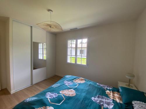 une chambre avec un lit avec une couette bleue dans l'établissement Les Nids de Galleben - La Villa Biscarrosse, à Liposthey