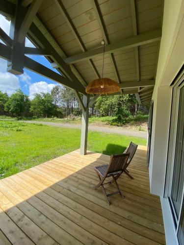 une chaise à bascule sur un porche avec un parasol dans l'établissement Les Nids de Galleben - La Villa Biscarrosse, à Liposthey