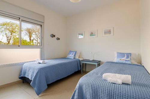 a bedroom with two beds and a window at GW002 Gugel Waves Amazing Seaview & Garden Family Apartments in Nahariyya
