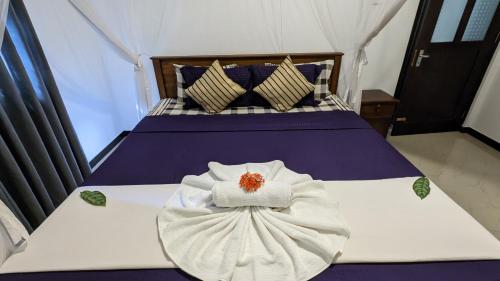 a bedroom with a bed with a towel on it at Galhena Villa in Tangalle