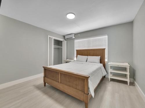 Un dormitorio con una cama grande y una ventana. en Modern Apt Near Beach – Views Wi-Fi, en Dania Beach