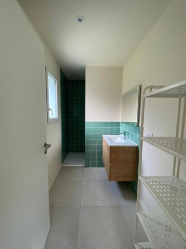 une salle de bain avec un lavabo et un miroir dans l'établissement Les Nids de Galleben - La Villa Mimizan, à Liposthey