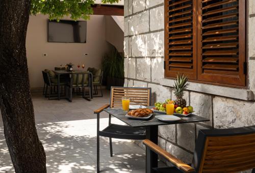 a table with a plate of food on a patio at Villa Peragro in Dubrovnik