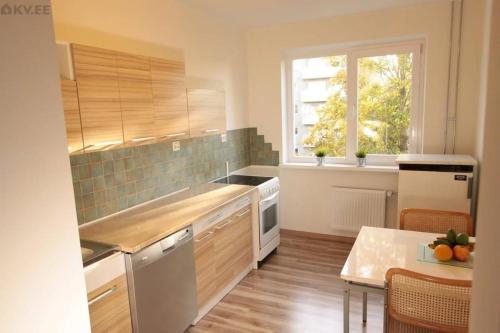 een keuken met een aanrecht, een tafel en een raam bij 2 in 4 Rooms Apartment in Tallinn