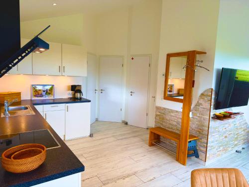 a kitchen with white cabinets and a counter with a mirror at Die 5 Ferienwohnungen der Familie Weber in Fehmarn