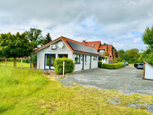 a house with a driveway in front of it at Die 5 Ferienwohnungen der Familie Weber in Fehmarn