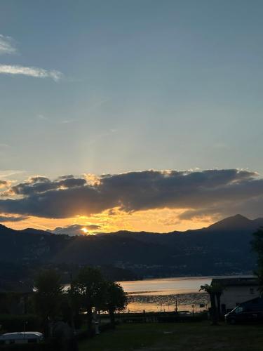 a sunset over a body of water with the sun setting at Camping BellaVista in Bolzano Novarese