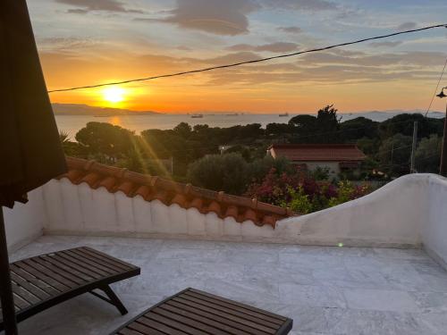 a sunset from the balcony of a house at Wunderschönes Haus mit Meerblick in Isthmia