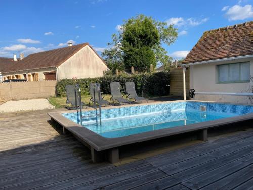 - une piscine avec des chaises dans l'arrière-cour dans l'établissement House Saint Laurent Nouan balneo and pool, à Saint-Laurent-Nouan